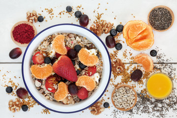 Healthy vegetarian breakfast superfood concept with fruit, muesli, smoothie juice, pollen grain, yoghurt, acai berry powder, chia seeds and nuts. High in omega 3, protein, antioxidants & vitamins.  