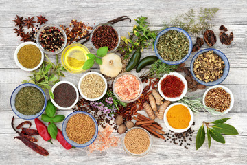 Spice and herb seasoning with fresh and dried herbs and spices with olive oil on rustic wood background. Top view.
