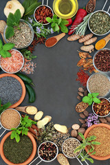 Herb and spice abstract background border with fresh and dried herbs and spices with olive oil on slate. Top view.