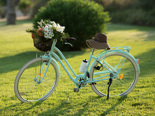 Fototapeta premium Beautiful blue bike with a basket of flowers