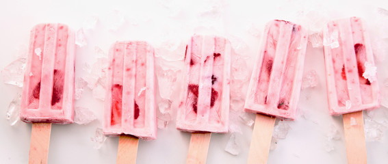 Row of healthy fresh strawberry frozen popsicles