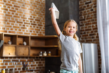 Waist up of positive girl holding a paper plane