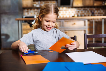 Cheerful little girl making a birthday card