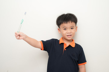 Cheerful little boy holding a tooth brush over white background, Studio portrait of a healthy mixed race boy with a toothbrush isolated.