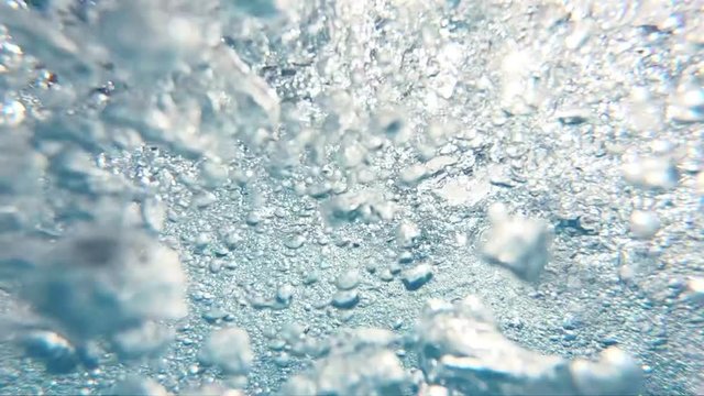 Professional video of blue underwater bubbles rising to surface in slow motion 250fps