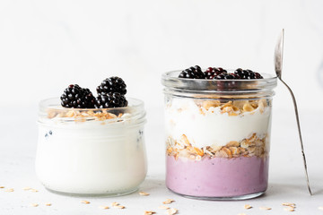 Breakfast parfait, overnight oats and greek yogurt in a jar on white background. Closeup view