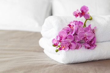 Fototapeta na wymiar towels and flower on bed in hotel room