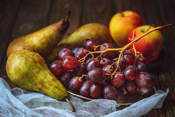 close-up shot of ripe grapes with pears and apples on cheesecloth