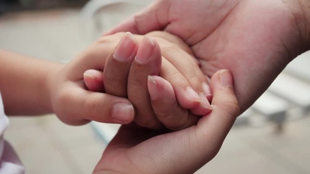 Hand of a child touching old hands of elder