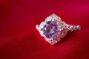 Jewelry luxury pink gold ring with sapphire gemstone on red fabric texture background