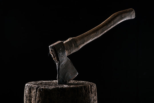  close up view of vintage axe on wooden stump isolated on black