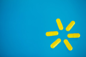 Obraz premium Pigułki medyczne. Kolorowe Pigułki I Kapsułki Na Niebieskim Tle. Motyw apteki, tabletki w kapsułkach z antybiotykiem w opakowaniach