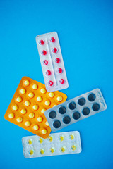 Medical Pills. Colored Pills And Capsule On Blue Background. Pharmacy Theme, Capsule Pills With Medicine Antibiotic in Packages