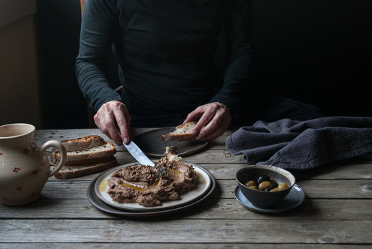 Man spreading lentil pate on bread