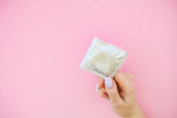 Contraception. Birth Control Pills and an unwrapped Condom. Colored Pills And Capsule On Pink Background. Pharmacy Theme, Capsule Pills With Medicine Antibiotic in Packages