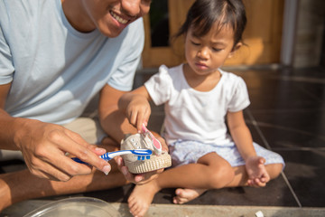 Fototapeta premium father with her toddler girl washing their shoes together 