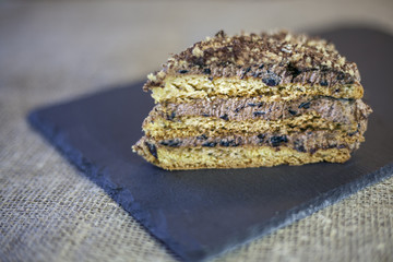 cake with walnuts, prunes and dried apricots on a dark wood background, selective focus
