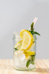 Frische limonade mit frischen Zitronen und Eiswürfeln in einem Glas mit Strohhalm