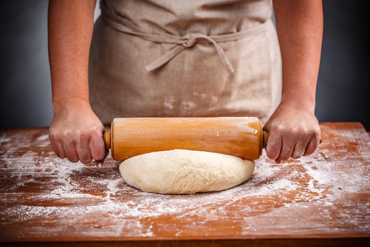 Housewife flattening a dough