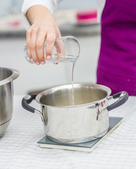 close-up womans hands weighs ingredients for cake