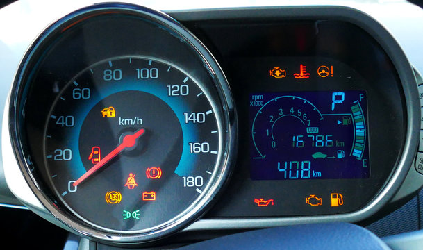 Sustem check on engine start. Speedometer and tachometer with additional instruments on car dashboard.