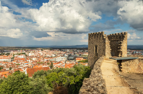Castle tower of Castelo Branco, Portugal, with the city in the background and a sky with large clouds.