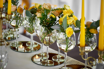 Yellow flowers details of the wedding table decorated with flowers. Floristic