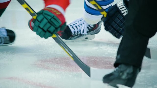 slow motion macro puck falls on ice after face-off rotating