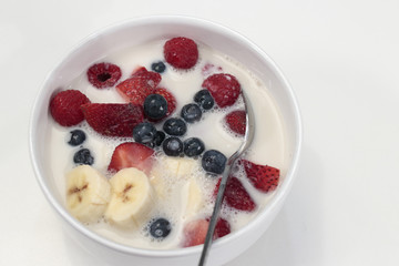 Bowl with Mixed Fruit Berry Variety and Almond Milk over Cereal