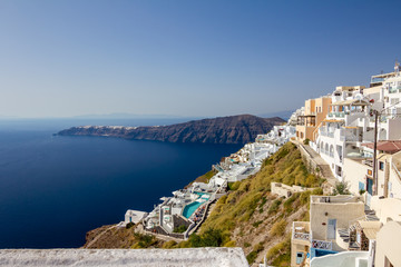 Fototapeta na wymiar Terrace with view, incredibly romantic scene, Santorini. Fira, Greece. Amazing daytime cityscape towards Oia and the deep sea crystal waters with white houses and swimming pools