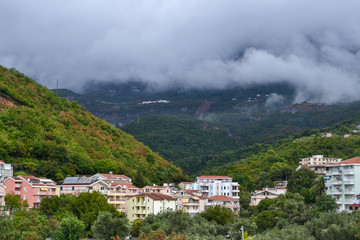 Fototapeta na wymiar Becici, Montenegro, View of the city and mountains. Low white clouds over the city