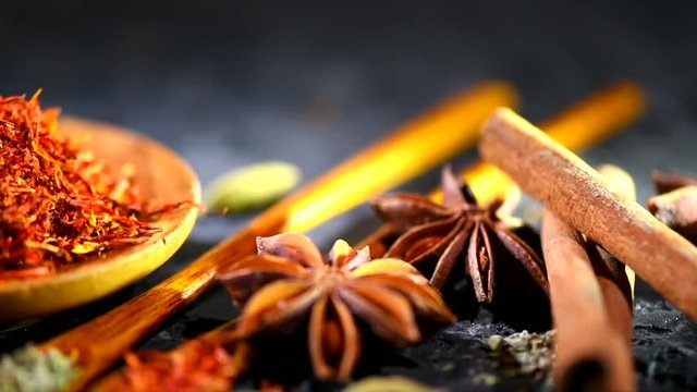 Spices. Various Indian spices on a dark stone table. Spice and herbs on black background. Dolly shot. Slow motion. 3840X2160 4K UHD video footage