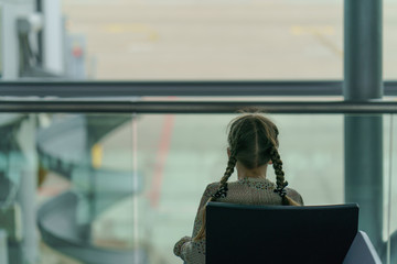 Girl waiting for her flight. Defocused backgroung image, bokeh