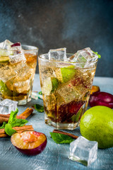 Summer iced refreshment drink. Cinnamon and plum lemonade cocktail, with fresh lime and mint, blue background copy space