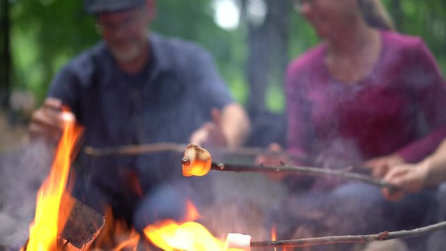 Closeup of marshmallows being roasted over a camfire.
