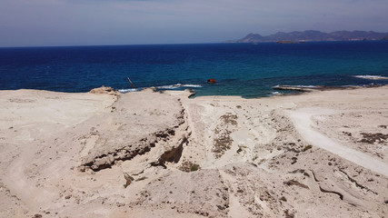 Aerial drone bird's eye view of iconic lunar volcanic white chalk iconic beach and caves of Sarakiniko, Milos island, Cyclades, Greece