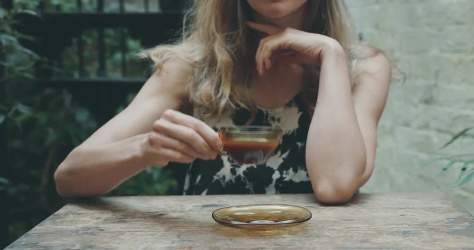 Young woman enjoying coffee in courtyard