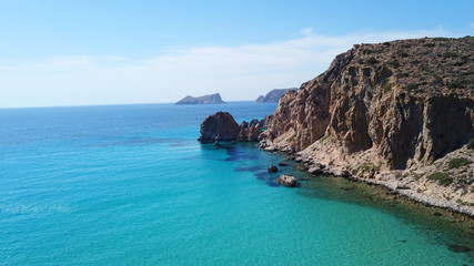 Aerial drone bird's eye view of volcanic and exotic rocky beach with turquoise and sapphire clear waters of Plathiena in island of Milos, Cyclades, Greece