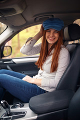 Smiling woman in the car enjoying in road trip and having fun