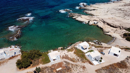 Aerial drone bird's eye view photo of picturesque small fishing harbor of Mandrakia with boat houses called syrmata and fishing boats docked on turquoise clear waters, Milos island, Cyclades, Greece