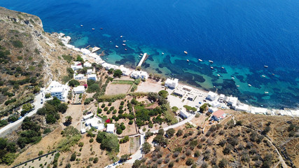 Aerial drone bird's eye view photo of picturesque and colourful fishing village of Klima with traditional character and uphill village of Plaka at the background, Milos island, Cyclades, Greece