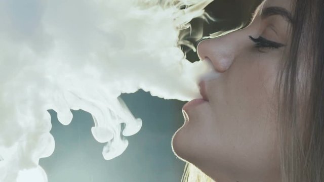 A girlfriend's face profile that burns an electronic cigarette