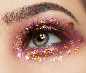 Macro and close-up creative make-up theme: beautiful female eyes with red shadows pigment and gold sparkles - 213239172