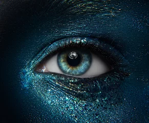 Fotobehang Macro en close-up creatief make-up thema: mooie vrouwelijke ogen met zwarte huid met een blauw-groen pigment schittert © Parad St