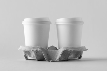 Two 12 oz. white coffee paper cups with lid in a holder. Blank Mock-Up.