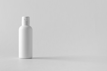 White plastic cosmetic lotion bottle mock-up with cap.