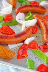 Vertical view of sausages sheet pan dinner with onions and peppers