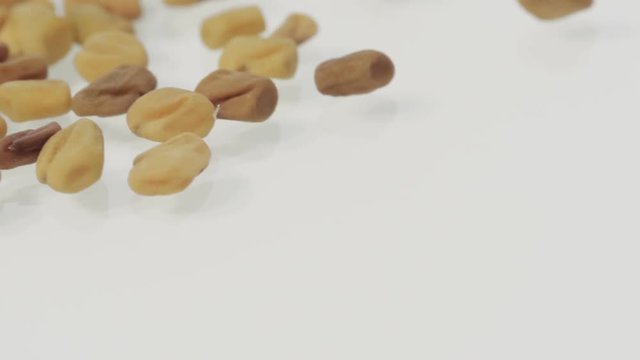 Close up of methi grains on turntable. 
Marco footage of rotating fenugreek seeds.