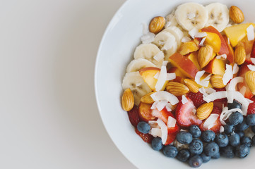 Healthy breakfast: oats with banana, peach, blueberry, strawberry, coconut flakes and almond. Vegan food