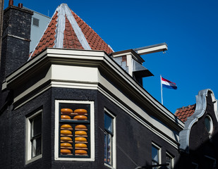 Fototapeta na wymiar Cheese wheels stacked in a window in Amsterdam, Netherlands